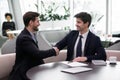 Two businessmen accomplish successful negotiations shaking hands Royalty Free Stock Photo