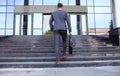 Business executive with briefcase going up the stairs. Royalty Free Stock Photo