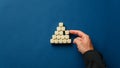 Business executive building a pyramid shape with wooden dices Royalty Free Stock Photo