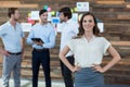 Business executive standing with hands on hip in office