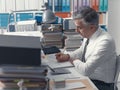 Businessman working in the office and piles of paperwork Royalty Free Stock Photo