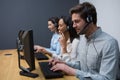 Business executives with headsets using computers at desk Royalty Free Stock Photo