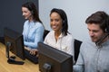 Business executives with headsets using computers at desk Royalty Free Stock Photo