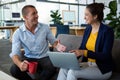 Business executives interacting with each other while using laptop Royalty Free Stock Photo