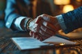 Business executives shake hands over key documents, formal business meeting image