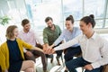 Business executives with their hands stacked while sitting