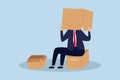 Business failure and fail entrepreneur concept, depressed businessman sitting covered his head with box, shameful cannot face