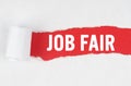 Behind torn white paper on a red background, the text - JOB FAIR
