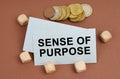 On a brown surface are coins, cubes and a business card with the inscription - Sense of Purpose Royalty Free Stock Photo