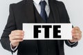 A businessman holds a sign in his hands which says FTE Royalty Free Stock Photo