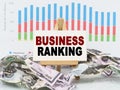 Among financial charts and money is a sign with the text - BUSINESS RANKING