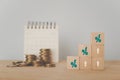 Business and finance concept increasing percentage on wooden cube block and blurred stack of coins and white calendar