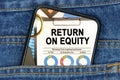 In a pocket of jeans there is a smartphone on the screen of which the text - RETURN ON EQUITY