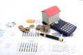 Business finance concept with red house with calculator and fountain pen and money coins on documaent report