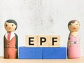Selective focus phrase EPF Employee Provided Fund on wooden cubes with a pair of wooden dolls.