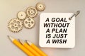 On the table are gears, pencils and a notebook with the inscription - A Goal Without a Plan Is Just a Wish Royalty Free Stock Photo