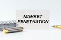 On the table is a notebook, a pen and a business card with the inscription - MARKET PENETRATION