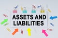 On the table there are paper clips and directional arrows, a sign that says - Assets and Liabilities Royalty Free Stock Photo