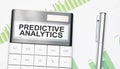 Business and finance concept. On the table there is a pen and calculator which the text is written PREDICTIVE ANALYTICS Royalty Free Stock Photo