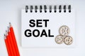 On a white background, there are red pencils, gears and a notebook with the inscription - SET GOAL Royalty Free Stock Photo