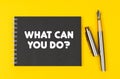 On a yellow background lies a pen and a black notebook with the inscription - What Can You Do Royalty Free Stock Photo