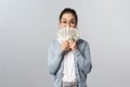 Business, finance and investment concept. Silly happy asian woman in glasses, holding cash of dollars near face, cover