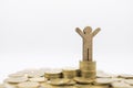 Business, Finance, Money Saving and Success Concept. Close up of wooden man figure  on top of stack of gold coins on white Royalty Free Stock Photo