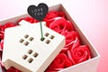 Wood house model with love you tag and red roses on red background with copy space for adding or mock up Royalty Free Stock Photo