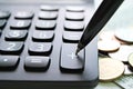 Pen press on plus button calculator and coins on office desk table