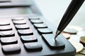 Pen press on plus button calculator and coins on office desk table