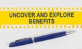 On the table are two sheets from a notebook and a pen on a yellow background written - UNCOVER AND EXPLORE BENEFITS Royalty Free Stock Photo