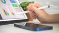 Business and financial diagram on the screen, office desk background. Female worker analyzing company perfomance on