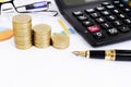 Fountain pen and coins stack and calculator eyeglasses on chart document Royalty Free Stock Photo