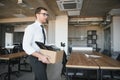 business, firing and job loss concept - fired male office worker with box of his personal stuff.