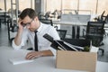 business, firing and job loss concept - fired male office worker with box of his personal stuff.