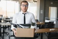 business, firing and job loss concept - fired male office worker with box of his personal stuff.