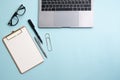 Business flat lay: desk with notebook, pencil, glasses on blue table. Royalty Free Stock Photo