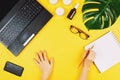 Business flatlay with laptop, mobile phone, glasses, philodendron leaf, candles, cream and other accessories