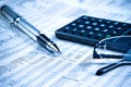 Business fountain pen, calculator and glasses on financial chart Royalty Free Stock Photo