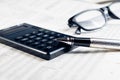 Business fountain pen, calculator and glasses on financial chart Royalty Free Stock Photo