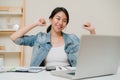 Business freelance woman stretching her body because feel tired after working on laptop, smart female working at home. Lifestyle Royalty Free Stock Photo