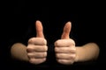 Business gesture. Thumb up close-up. Black background with copy space