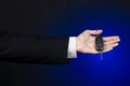 Business and gift theme: car salesman in a black suit holds the keys to a new car on a dark blue background in studio Royalty Free Stock Photo