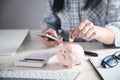 Business girl putting coin in a piggy bank. Saving money Royalty Free Stock Photo