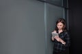 Hipster freelancer woman holding a tablet and standing near a business idea sketch on blackboard