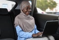 Business On The Go. Black Muslim Businesswoman Working On Laptop In Car Royalty Free Stock Photo