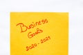 Business goals 2020-2021 handwriting text close up isolated on orange paper with copy space. Writing text on memo post reminder
