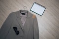 Business gray jacket on a hanger with sunglasses and a notebook