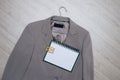 Business gray jacket on a hanger with sunglasses and a notebook