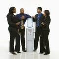 Business group standing around water cooler. Royalty Free Stock Photo